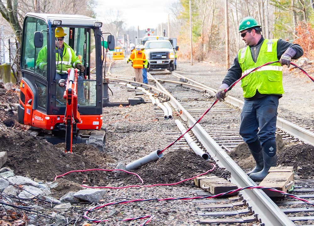 A crew installs track signal communication line near Walpole Station on the Franklin Line of the Commuter Rail (January 2020)