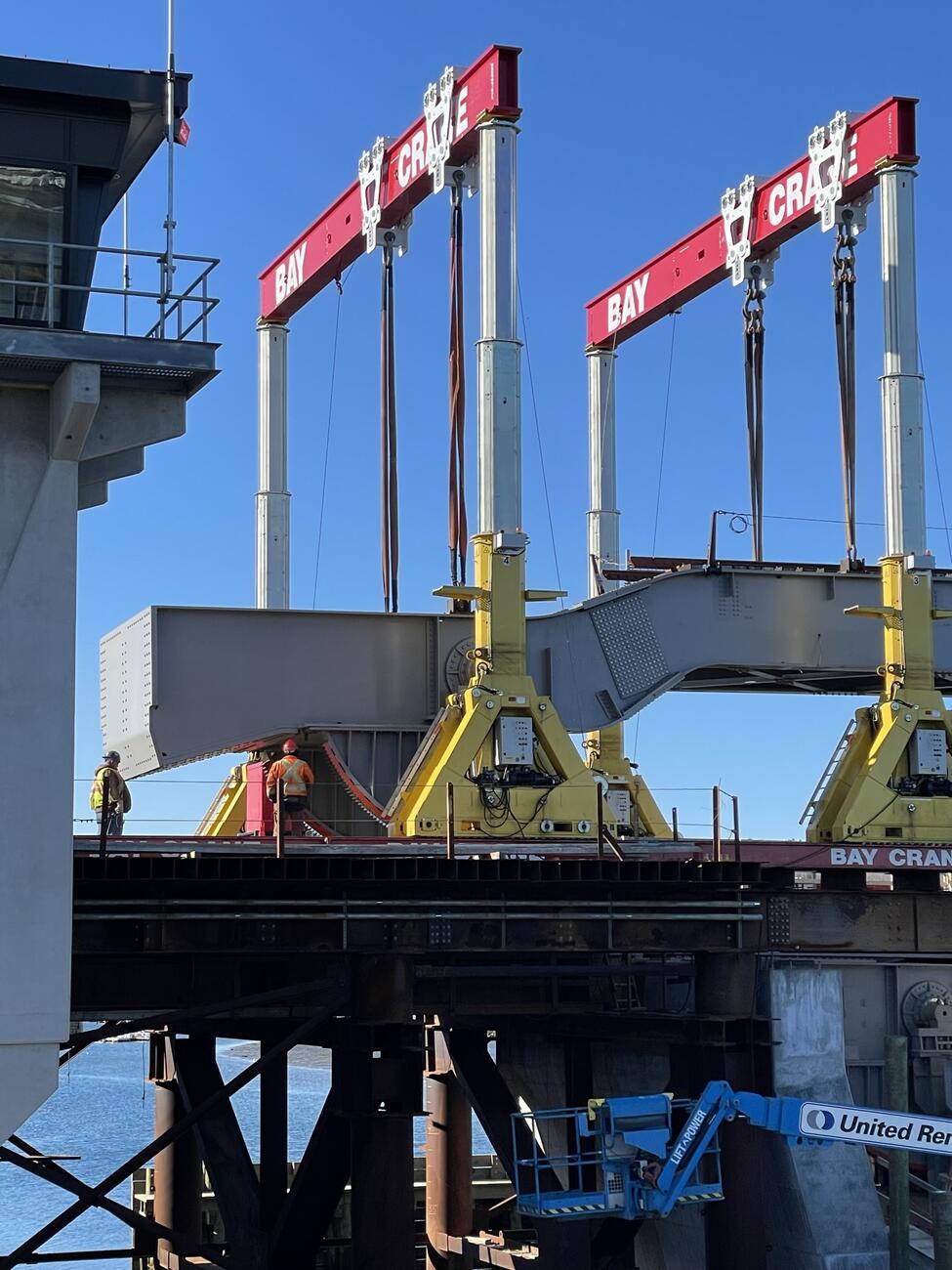 Close-up of a large gantry crane lifting the new bascule span off the self-propelled modular transporters