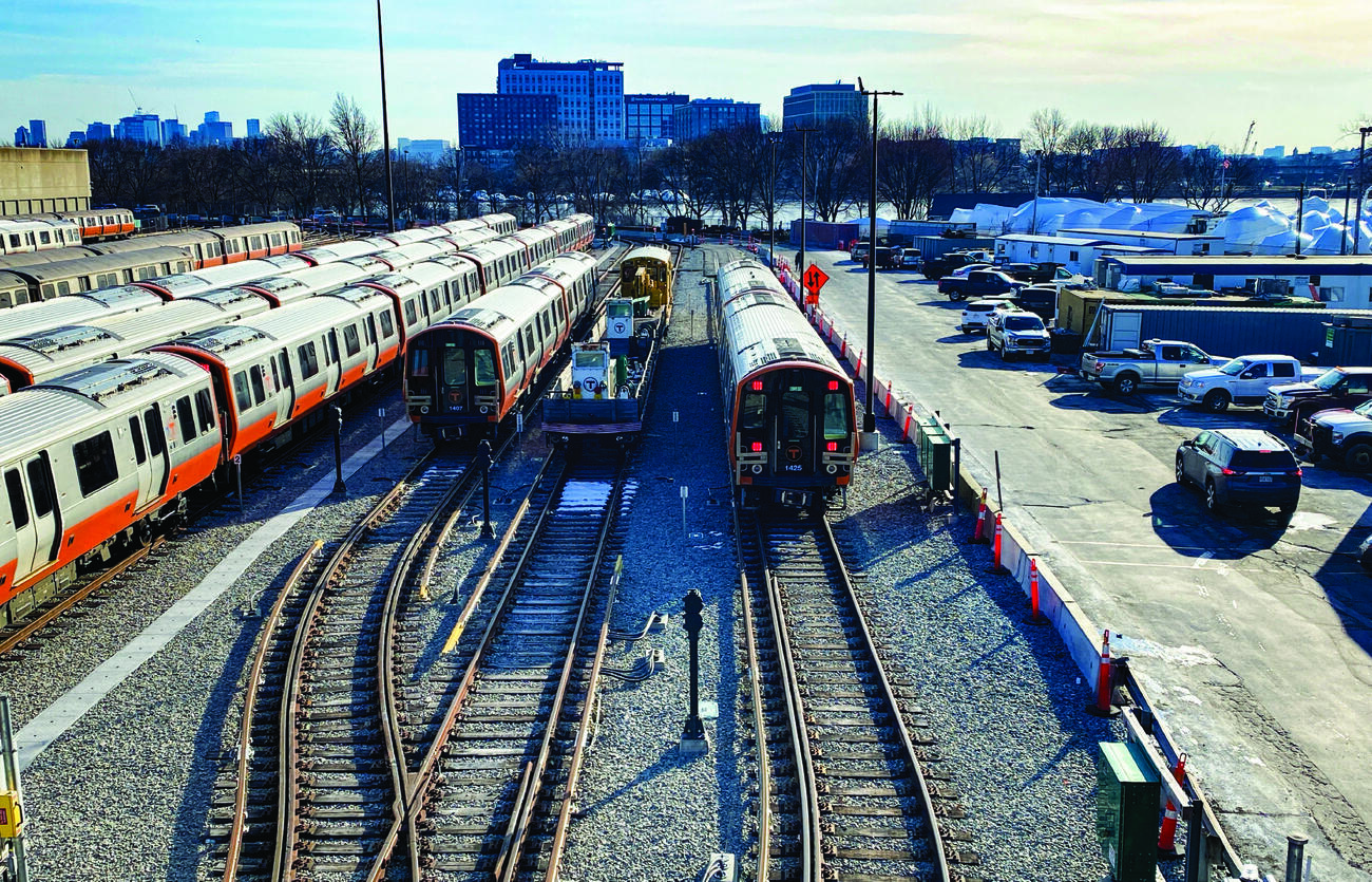 a photo of many sets of new orange line cars on storage tracks on a sunny winter day