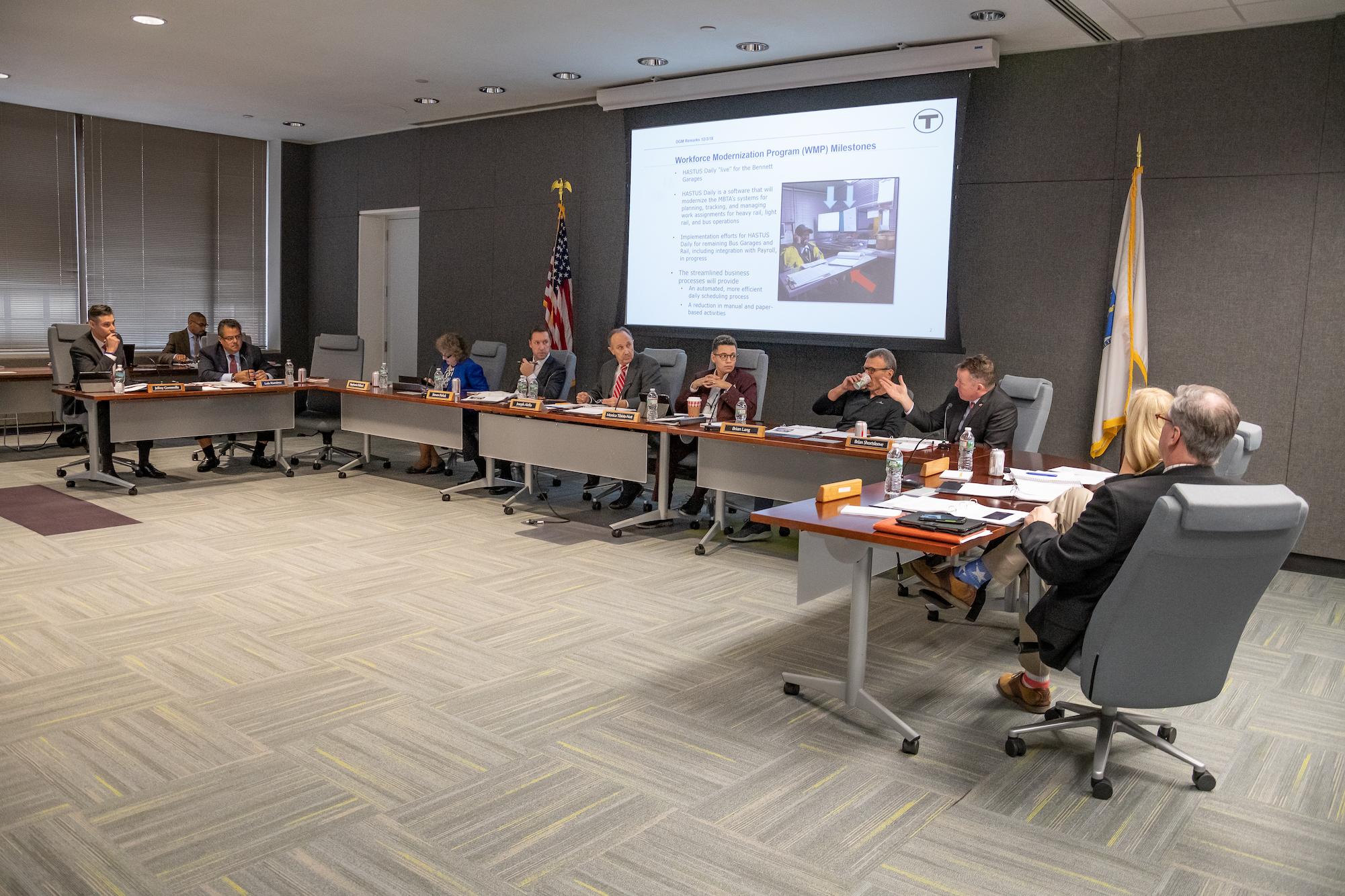 FMCB meeting, board members at the table, with a screen behind them