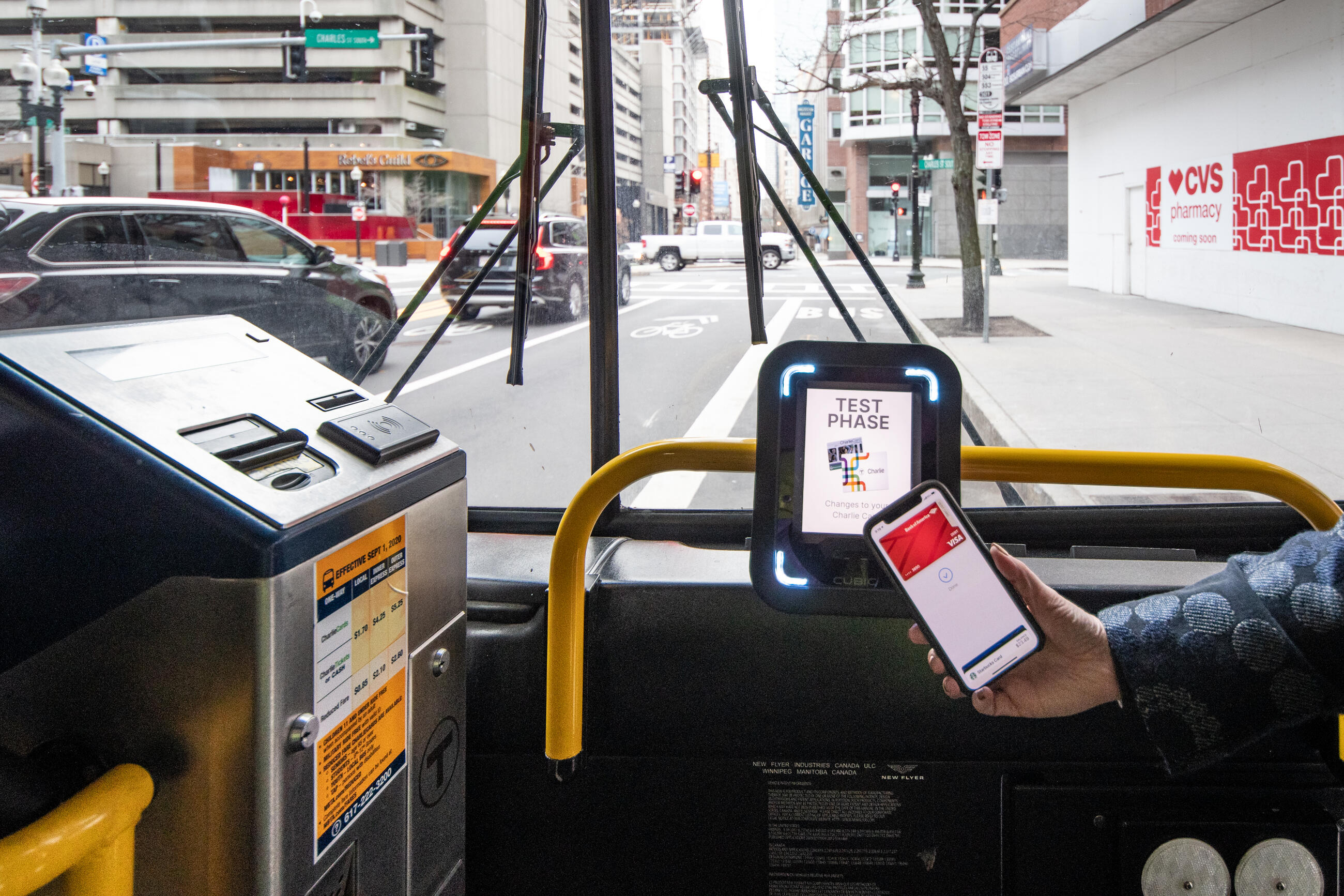 A rider taps their phone at one of the new CharlieCard reader prototypes installed on bus routes 28 and 39