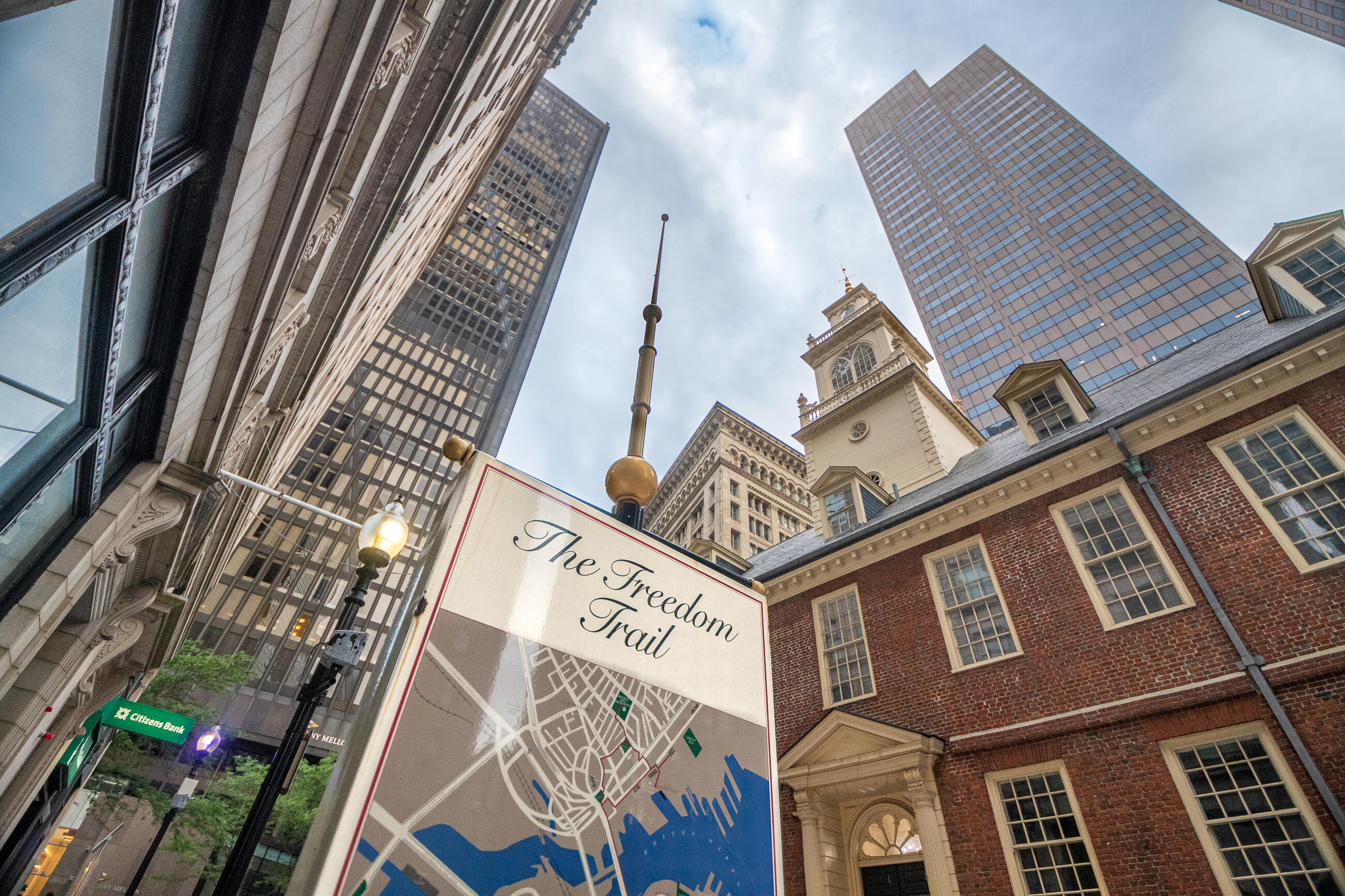 A large standing sign with a map of the Freedom Trail. The Old State House is in the background