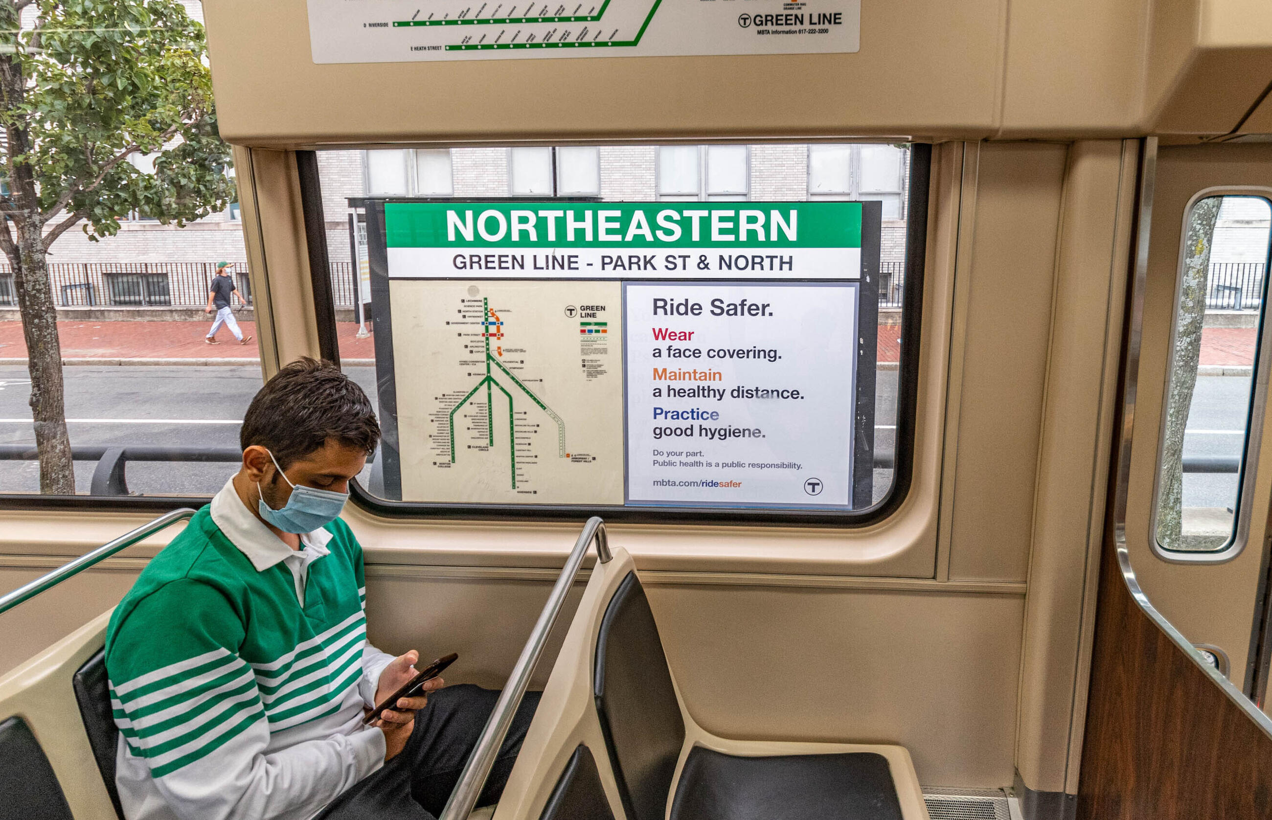 Person on the green line, with a Ride Safer sign in the background