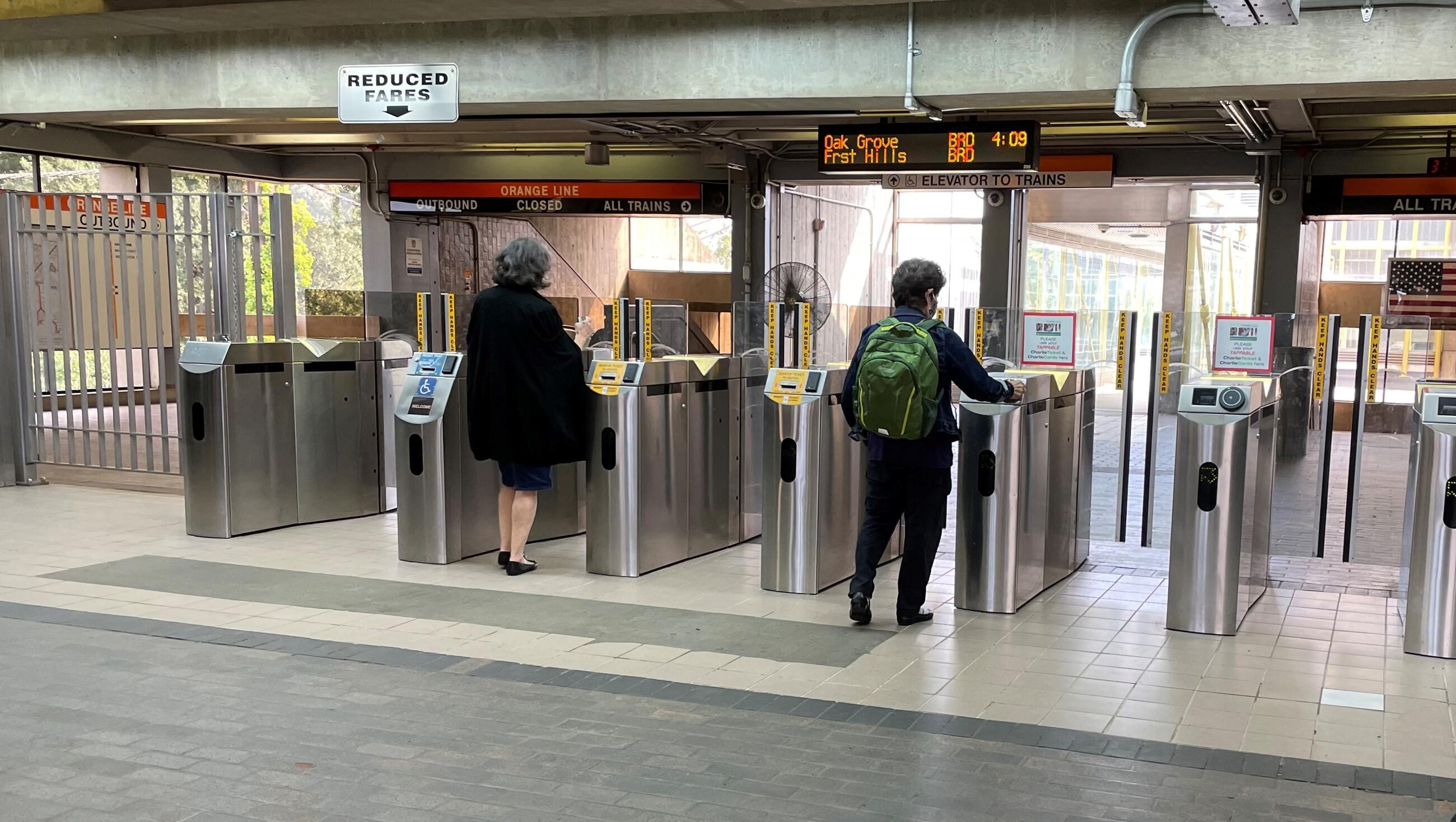 A rider taps their CharlieCard at one of the upgraded fare gates on the Orange Line
