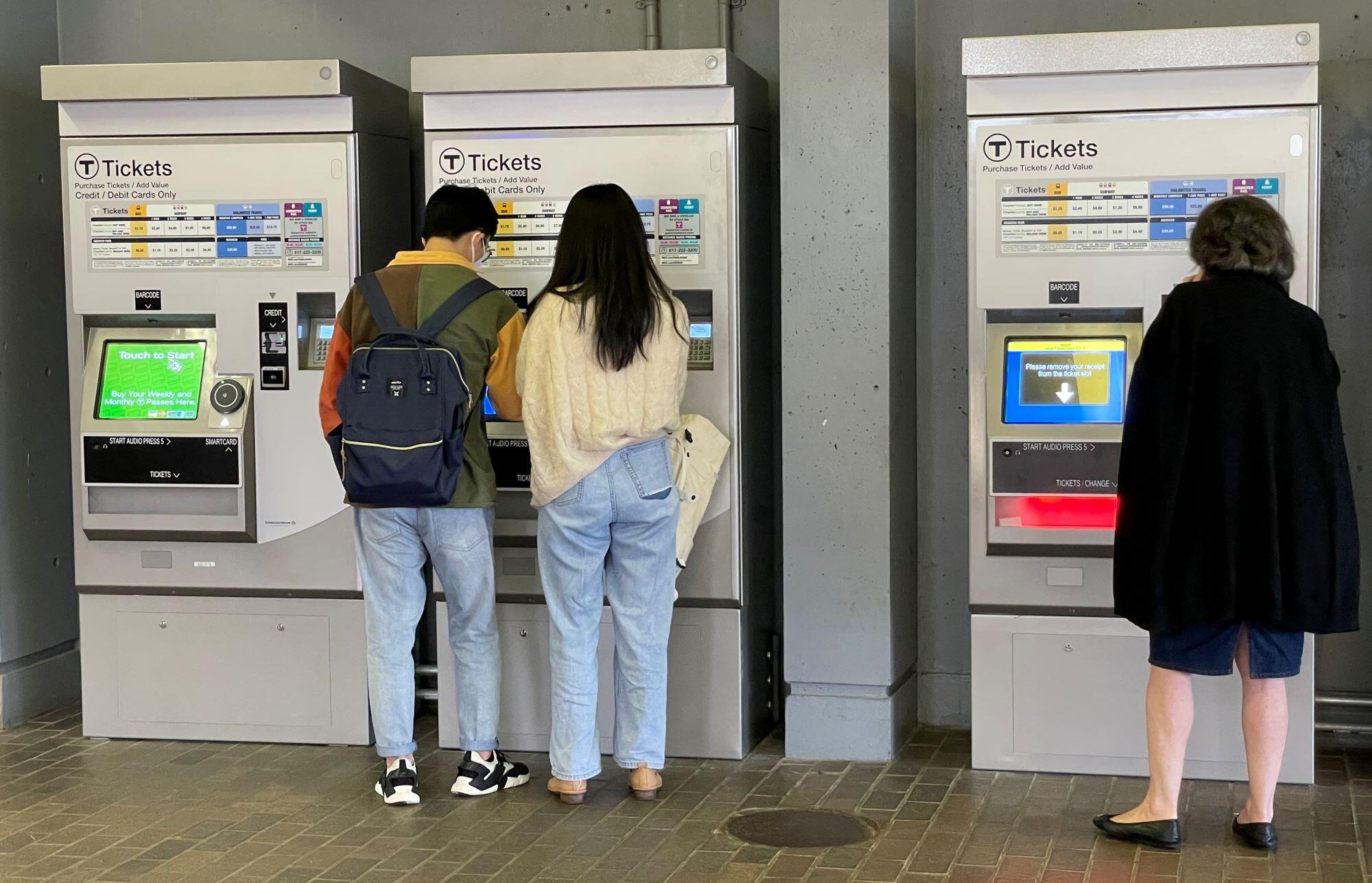 Riders use the new fare vending machines that were installed on the Orange Line in 2021