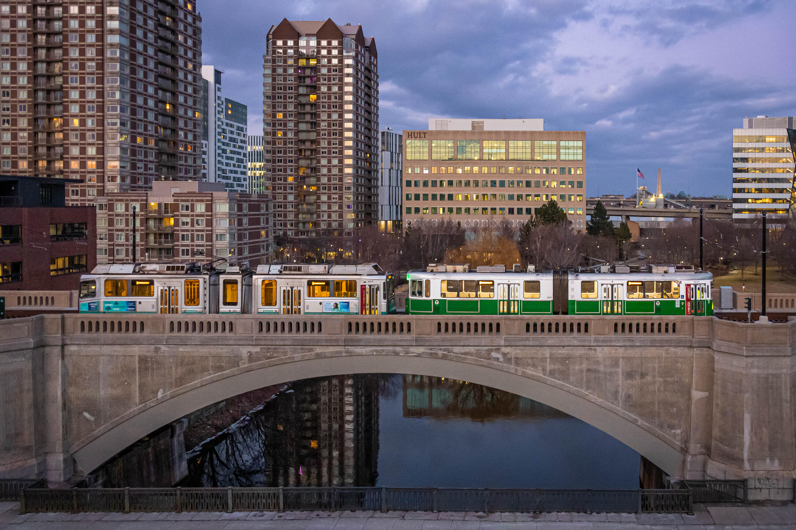 an empty green line test train on the lechmere viaduct, with a pretty purple sky as a backdrop