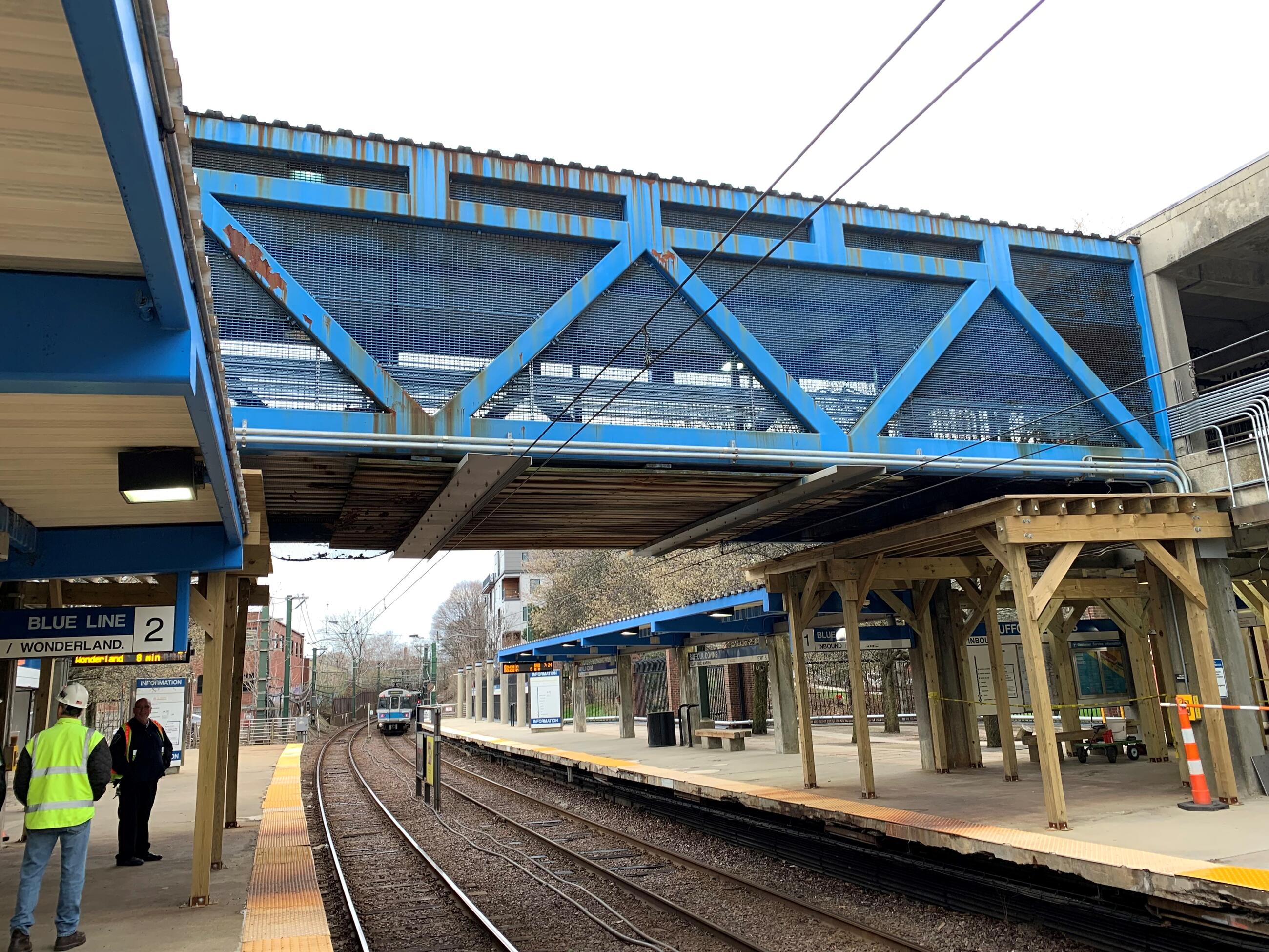 The blue-painted steel pedestrian bridge at Suffolk Downs station on the Blue Line is closed for repairs to begin in spring 2022. The bridge connects the Bennington and Walley street platforms.
