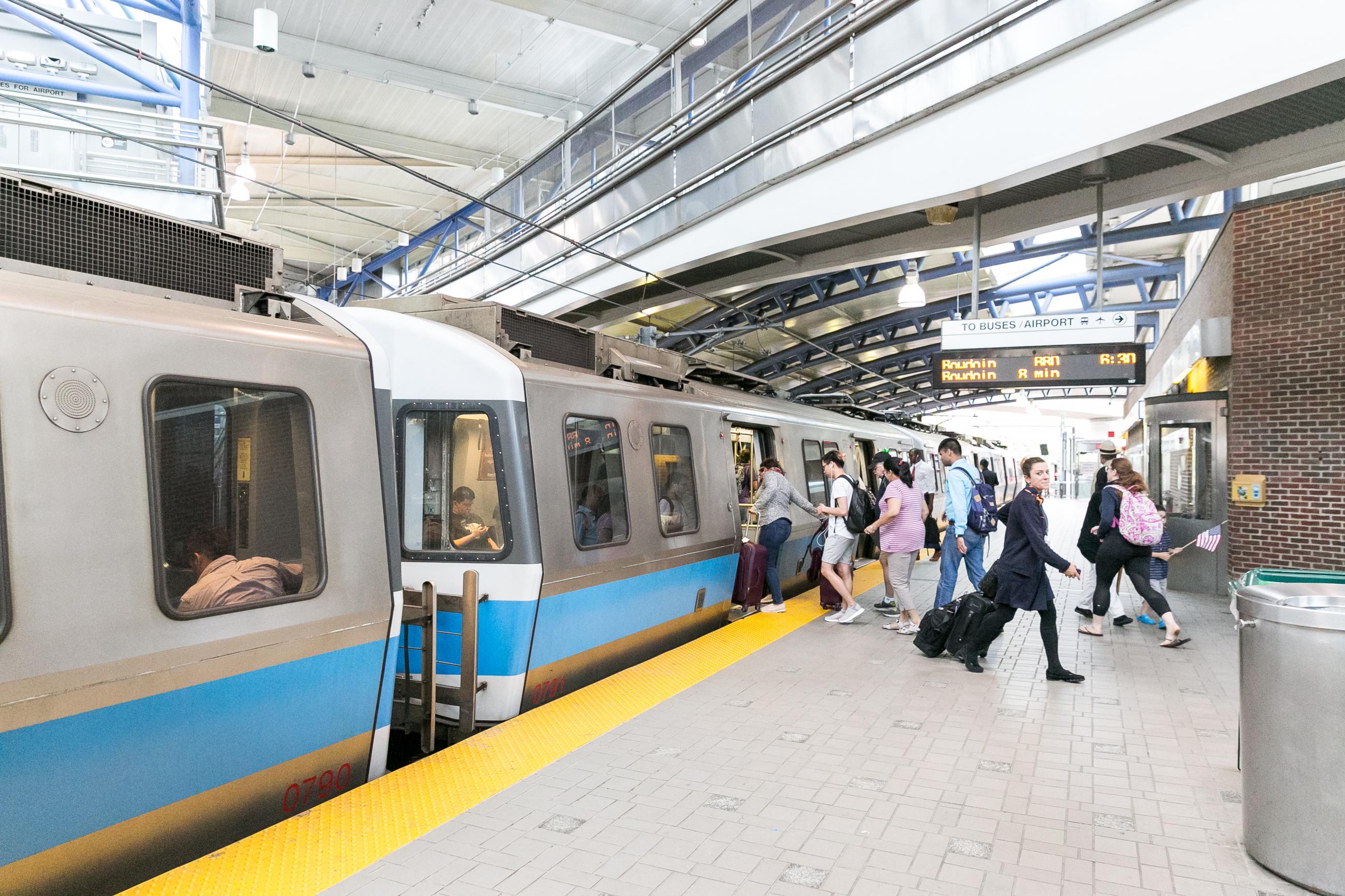 Riders exit an outbound Blue Line train at Airport station.