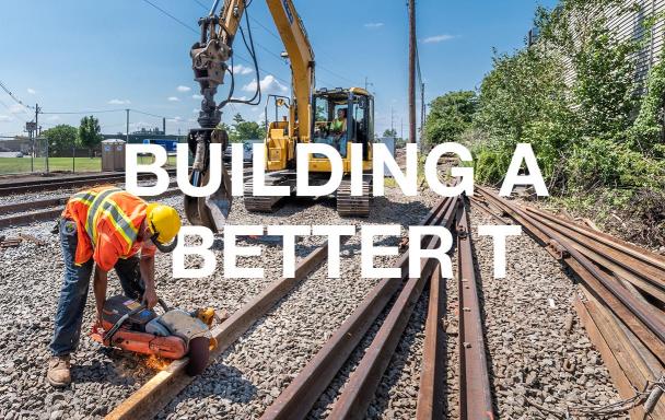 A crewperson in the foreground cuts rail while another crewperson sits in heavy machinery in the bakground. White text overlaid reads "Building a Better T."